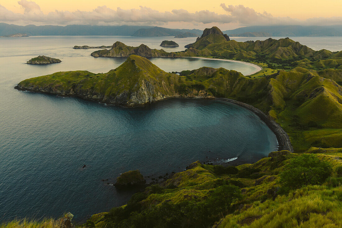View of the bay with a black sand beach and a white sand beach in the background at Padar Island in Komodo National Park in the Komodo Archipelago at sunset; East Nusa Tenggara, Indonesia