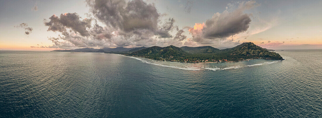 Luftaufnahme von Gili Trawangan und den Gili-Inseln in der Lombok-Straße mit dramatischen Wolkenformationen über den Inseln und einem pastellfarbenen Himmel; West Nusa Tenggara, Indonesien