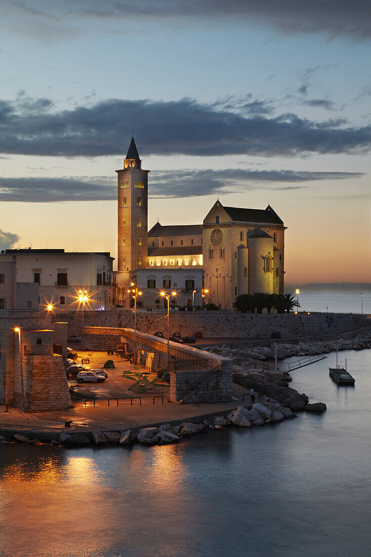 Ein Blick in der Abenddämmerung auf die Kathedrale und den Hafen von Trani; Trani, Apulien, Italien.