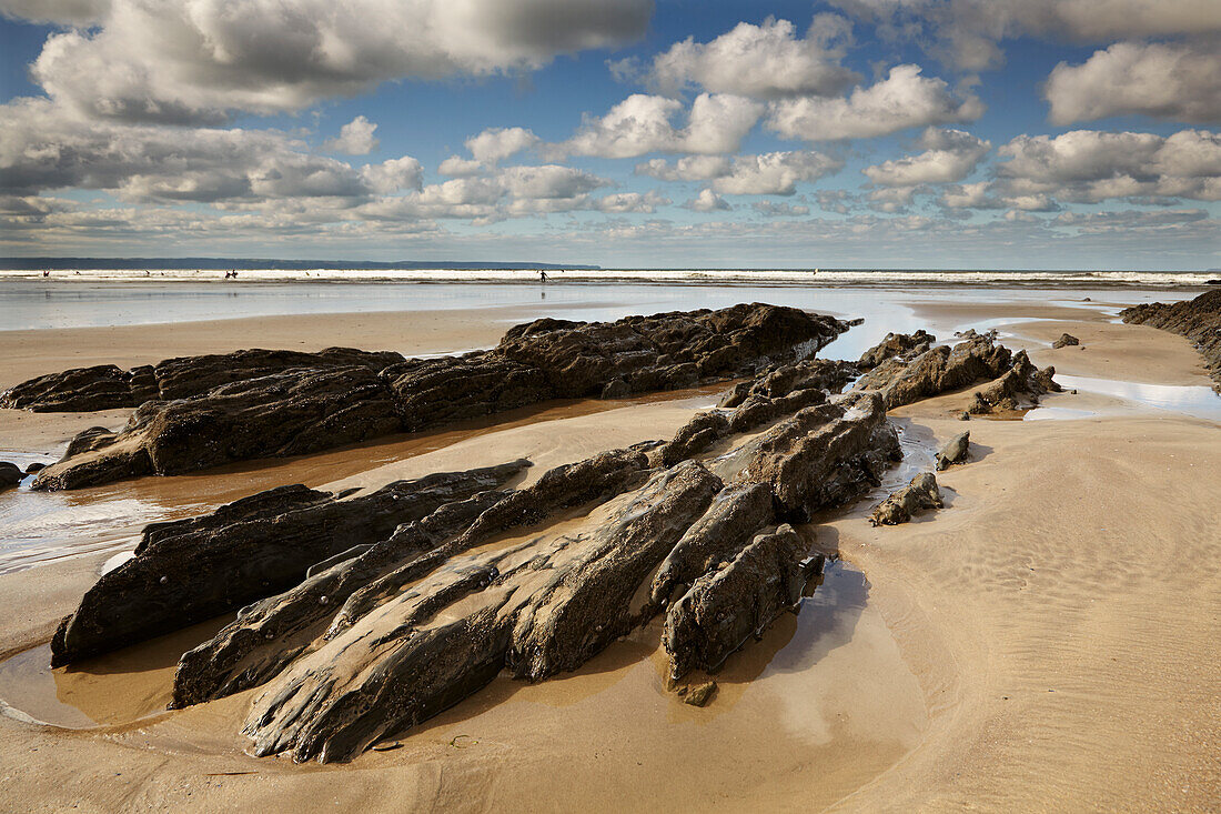 Felsen und Tümpel an einem Strand bei Ebbe, bei Saunton Sands, Devon, England, Großbritannien; Saunton Sands, Braunton, Barnstaple, Nord-Devon, Südwest-England, Großbritannien, Vereinigtes Königreich.