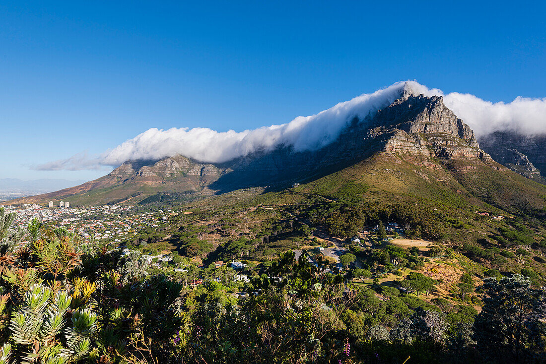 Cloud formation creating the tablecloth effect over Table Mountain with an overview of Cape Town city skyline from Signal Hill; Cape Town, Western Cape Province, South Africa