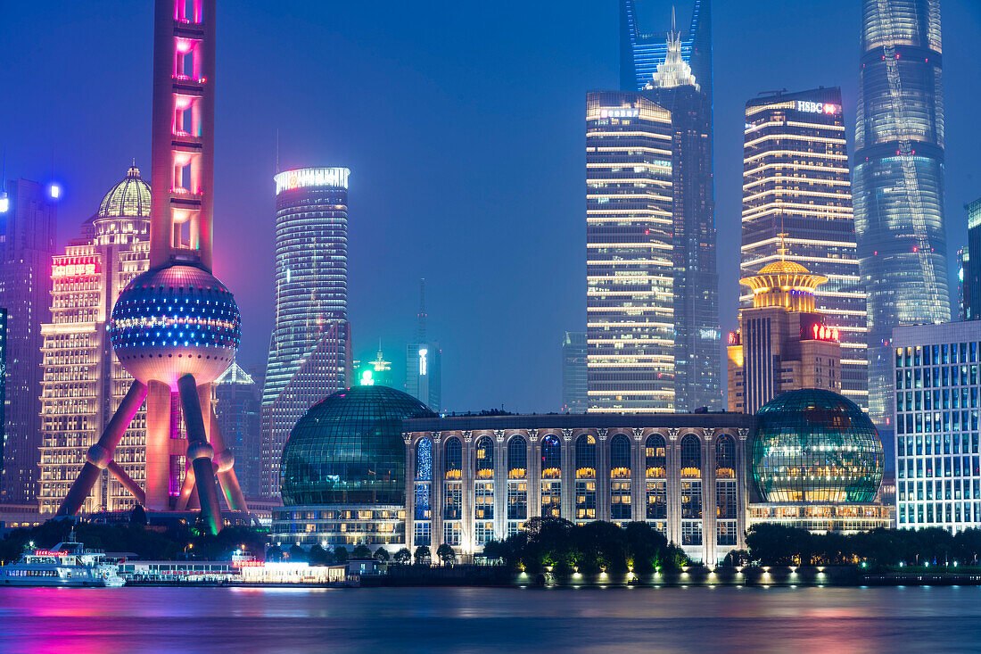 Blick über den Huangpu-Fluss (ein Nebenfluss des Jangtse) auf die Skyline von Shanghai in der Abenddämmerung; Shanghai, Shanghai Shi, China