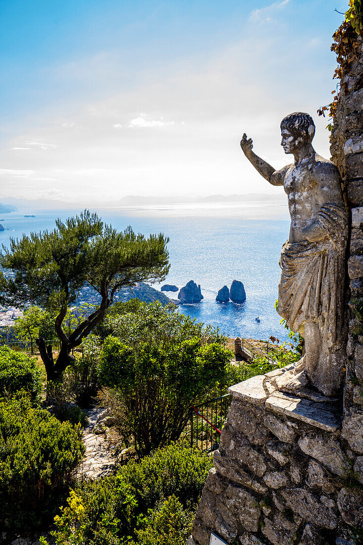 Statue des römischen Kaisers Tiberius mit Blick auf die Faraglioni-Bucht und Felsformationen vom Monte Solaro auf der Insel Capri; Neapel, Capri, Italien