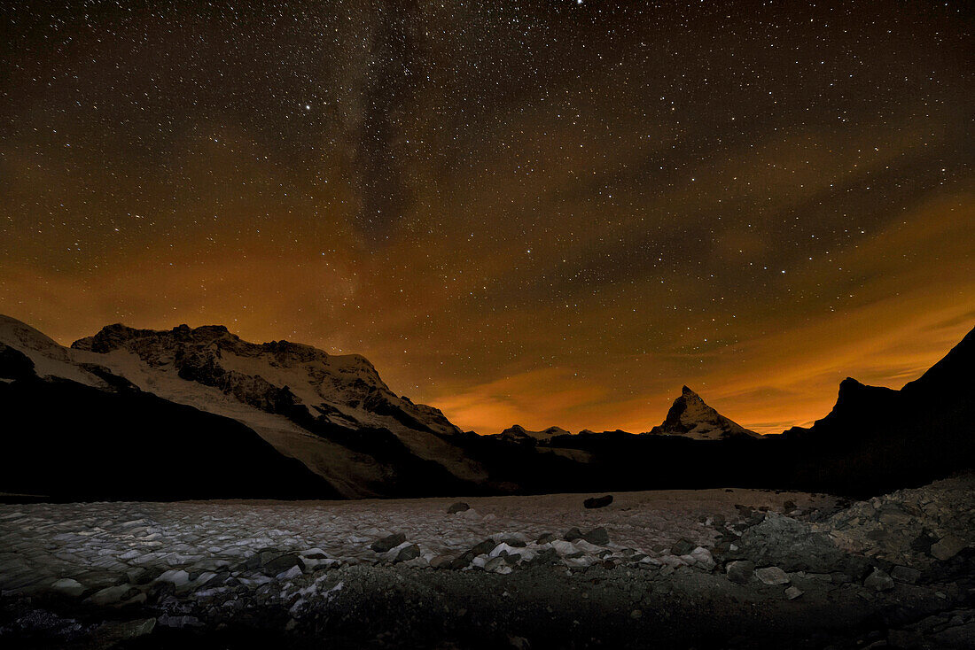 The Matterhorn mountain looms above the Gorner Glacier at night.; Gornergrat, Zermatt, Switzerland.