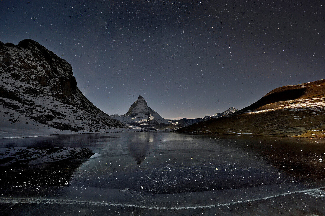 The Matterhorn looms above a frozen lake.; Gornergrat, Zermatt, Switzerland.