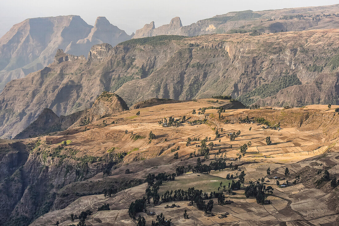 Scenic view of jagged mountain peaks with patchwork farmland on a plateau in the Simen Mountains in Northern Ethiopia; Simien Mountains National Park, Ethiopia