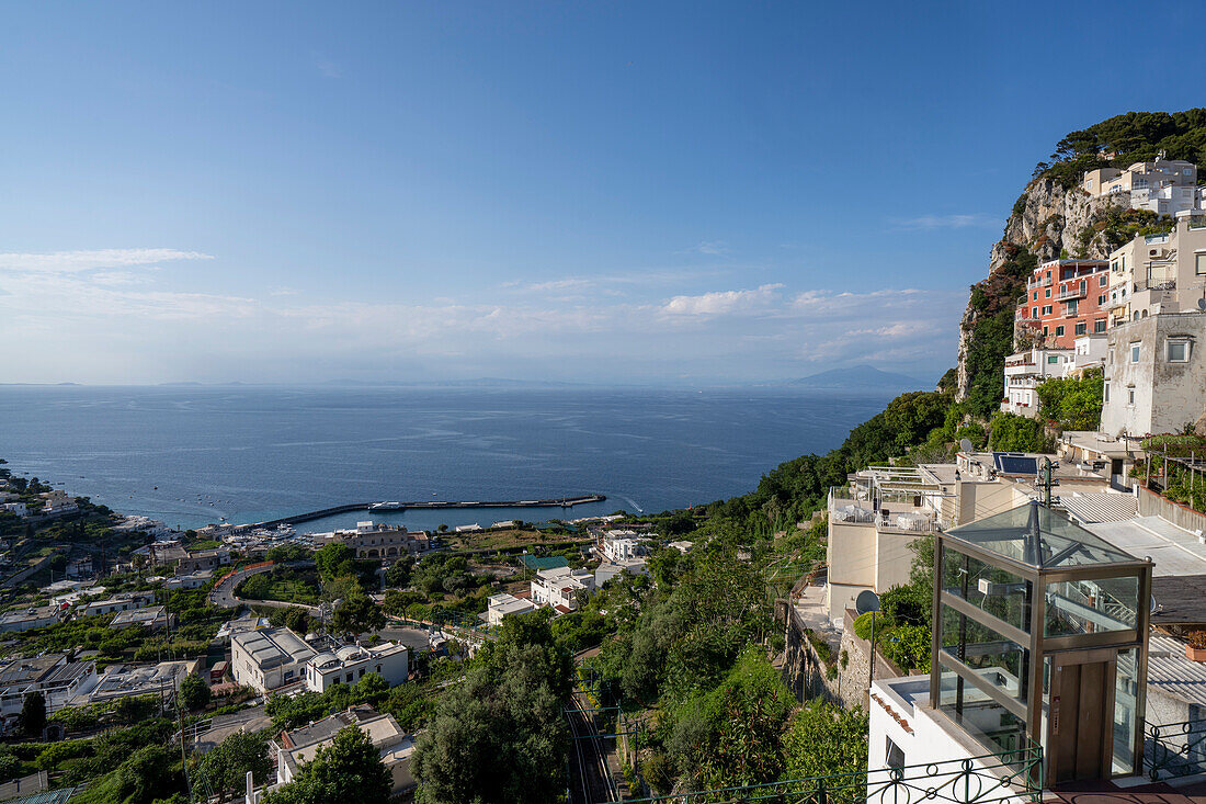 Capri-Stadt auf einem sattelförmigen Plateau hoch über dem Meer mit dem Hafen der Insel, Marina Grande, darunter; Neapel, Capri, Italien