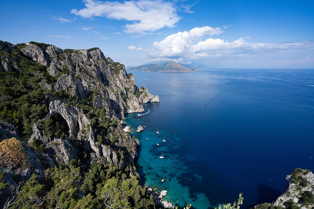 Blick von den felsigen Klippen auf der Insel Capri über die Amalfiküste und die Bucht von Neapel mit vor der Küste vertäuten Booten; Neapel, Capri, Italien