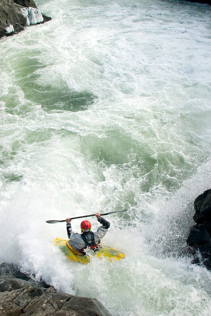 Wildwasserkajakfahrer paddelt vor einem Wasserfall; Potomac River, Maryland und Virginia.