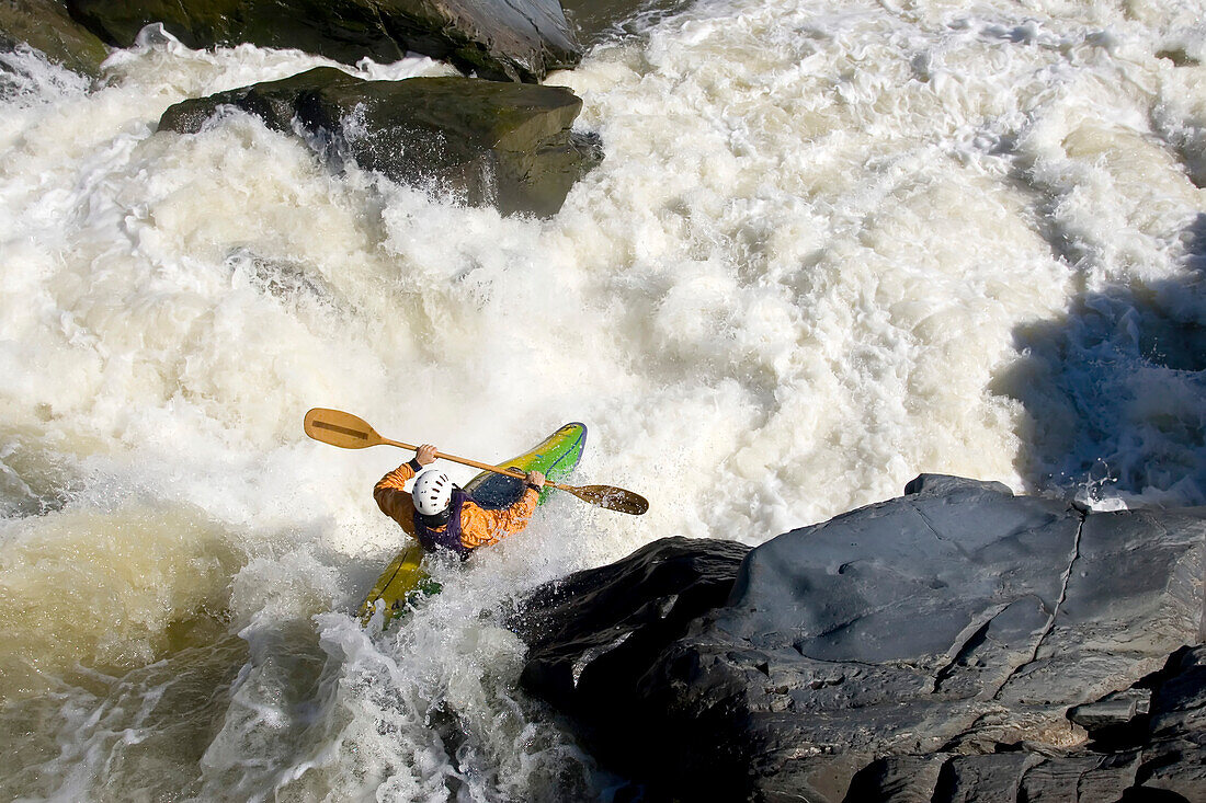 A kayaker paddles off a waterfall into big whitewater.; Great Falls, Potomac River, Virginia.