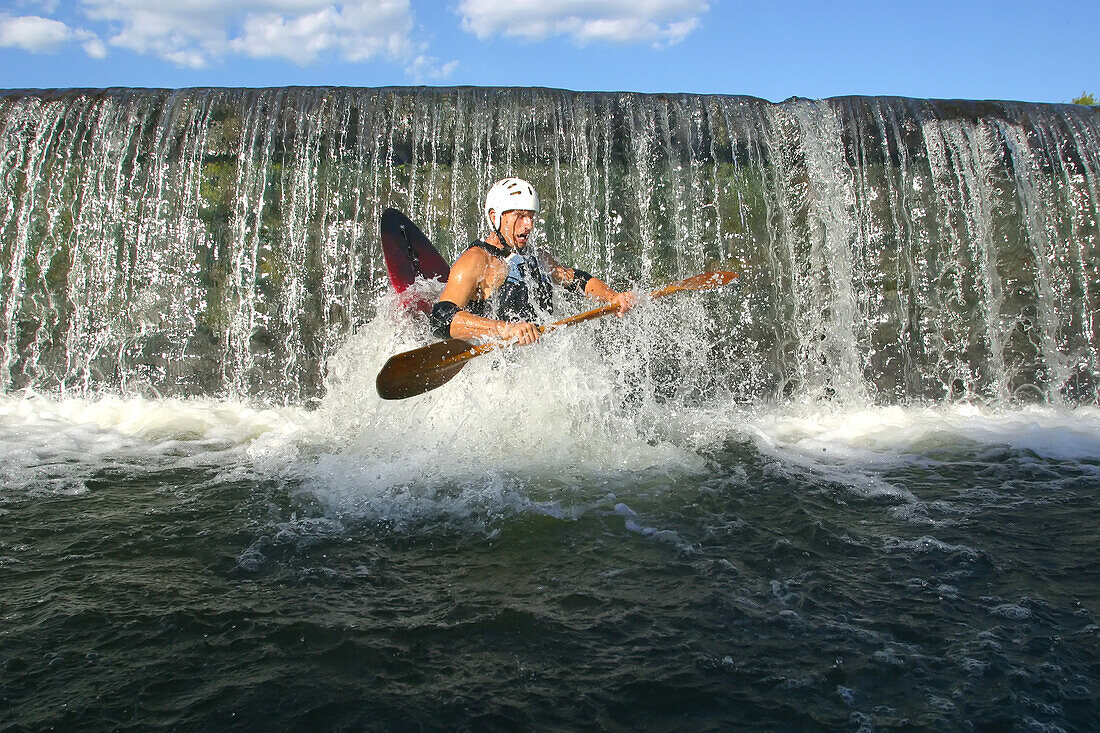 Ein Kajakfahrer taucht auf, nachdem er einen kleinen Damm auf dem Potomac River befahren hat; Potomac River, Maryland.