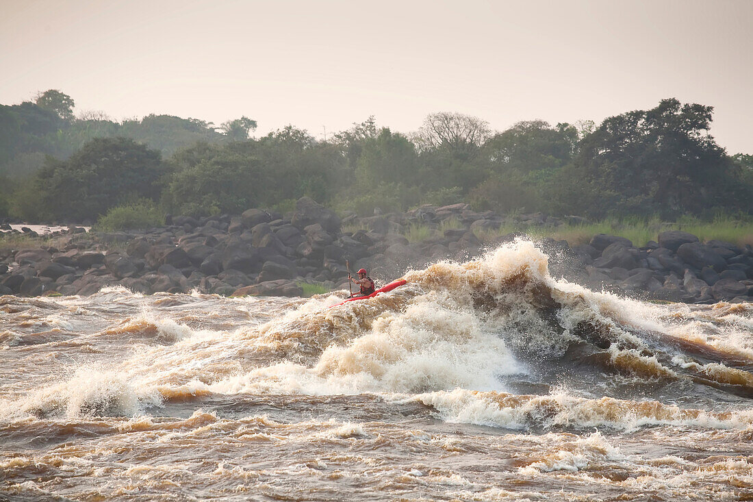 Ein Kajakfahrer paddelt durch die Kinsuka-Stromschnellen auf dem unteren Kongo-Fluss; Kongo-Fluss bei Kinshasa, Demokratische Republik Kongo.