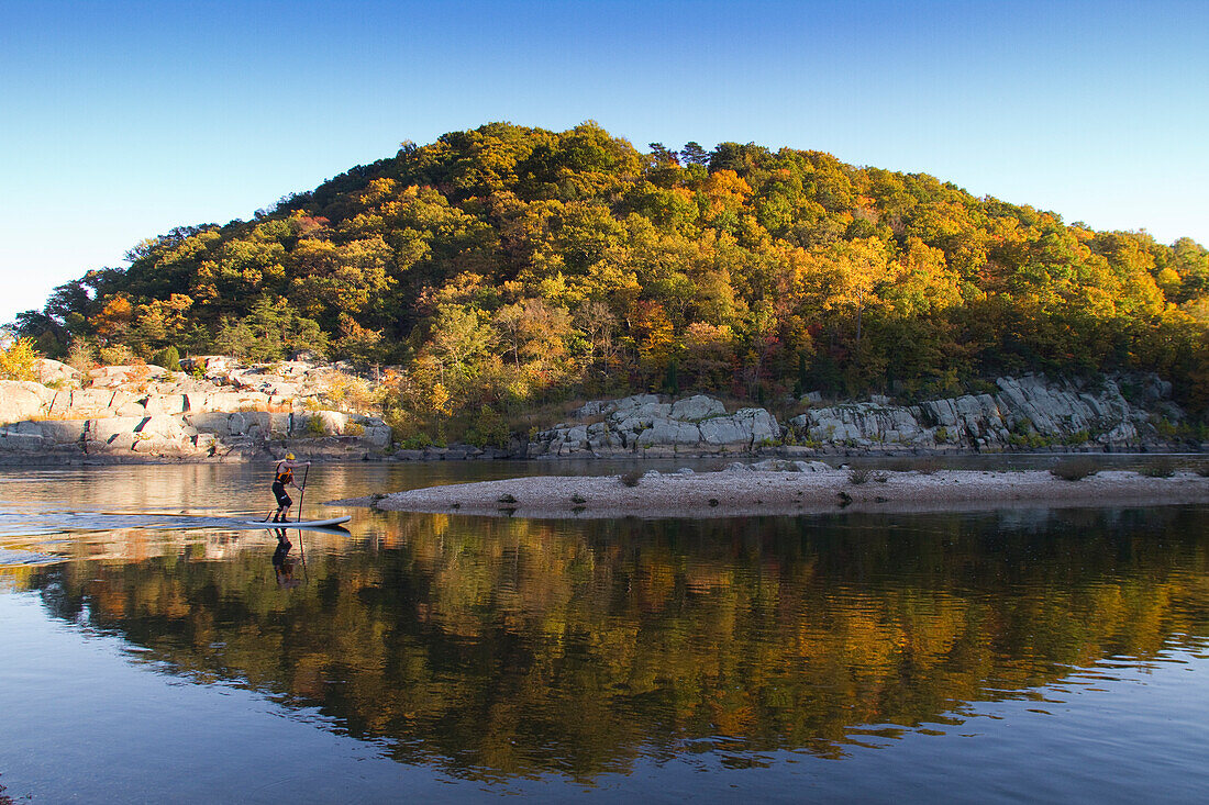 A stand up paddle boarder on the Potomac River.; Cabin John, Maryland.
