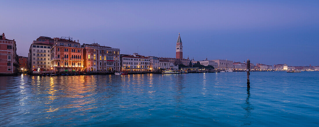 View of the City of Venice with the Campanile di San Marco, across the Grand Canal (Canal Grande) from the Punta della Dogana a la Salute in Veneto at twilight; Venice, Italy
