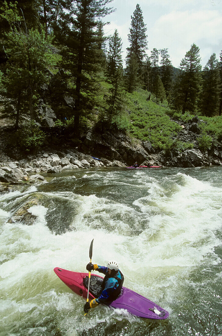 Ein Kajakfahrer paddelt, um durch die Stromschnellen zu kommen; Middle Fork of the Salmon River, Idaho