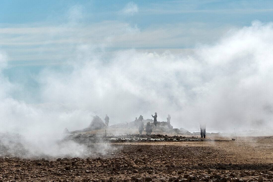 Menschen stehen am Aussichtspunkt und fotografieren den Myvatn-See, umgeben von dem Dampf, der aus den geothermischen Schloten aufsteigt. Das Myvatn-Seegebiet ist eine der geologisch aktivsten Regionen Islands; Myvatn-See, Nordisland, Island