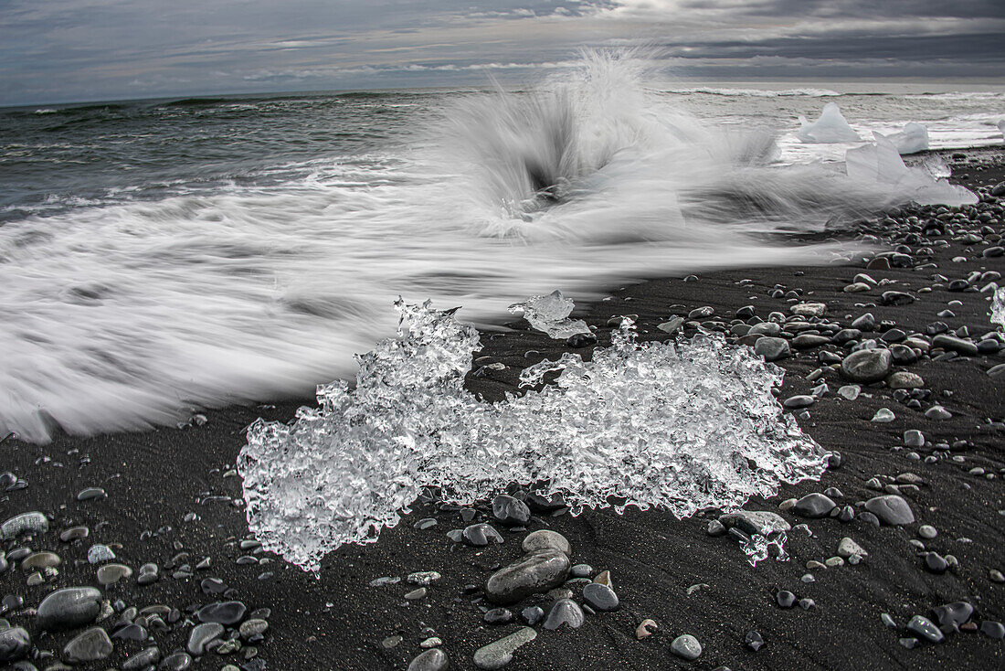 Waves crashing on the black sand beach at Jokulsarlon, the Glacier River Lagoon, where ice from the Vatnajokull Glacier falls into the lagoon and stay until they are small enough to float our to sea. Vatnajokull is the largest glacier in Iceland; Djupivogur, South Coast, Iceland