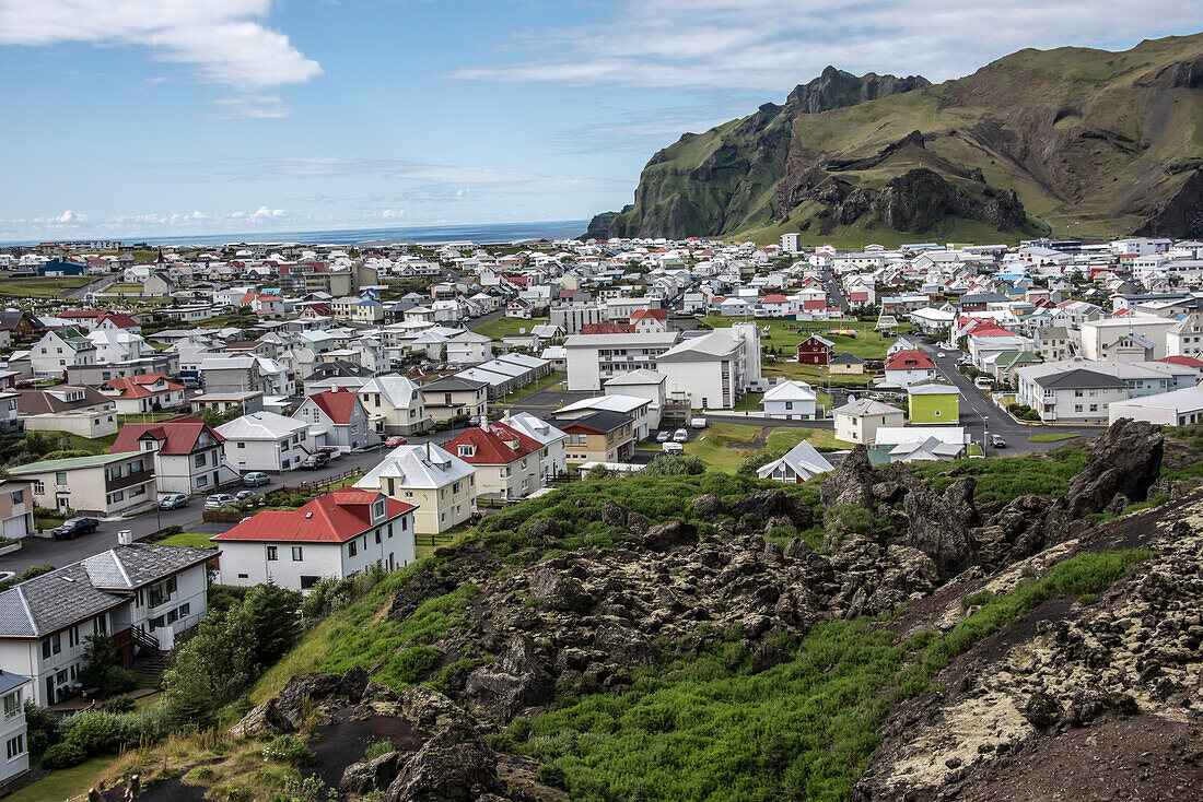 Lavaströme über den Häusern der Stadt auf der Insel Heimaey, die zu den Westmännerinseln gehört, einem Archipel von etwa 15 Inseln an der Südküste Islands, das vor etwa 11.000 Jahren entstand. Der Inselvulkan Eldfell explodierte am 23. Januar 1973. Die gesamte Bevölkerung der Insel wurde über Nacht evakuiert, mit Ausnahme von 300 Menschen, die zurückblieben, um den Lavastrom mit Wasserschläuchen zu bekämpfen; Stadt Heimaey, Insel Heimaey, Island