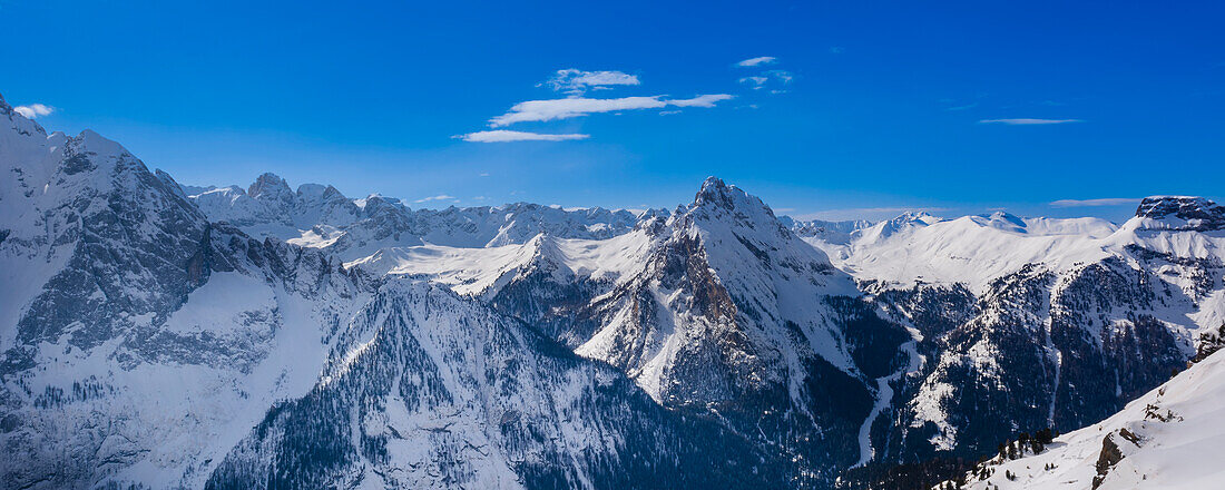 Überblick über die schneebedeckten Berggipfel und den blauen Himmel des Ciampac Skigebietes im Val di Fasso in der Nähe des Skigebietes von Canazei im Bezirk Trient; Trentino-Südtirol, Dolomiten, Italien