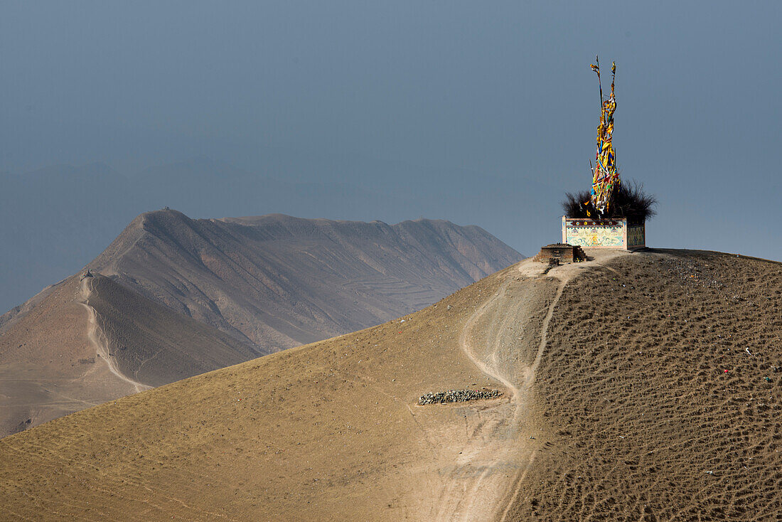 Turm aus buddhistischen Gebetsfahnen auf einem sandigen Berggipfel in Labrang; Labrang, Amdo, Tibet