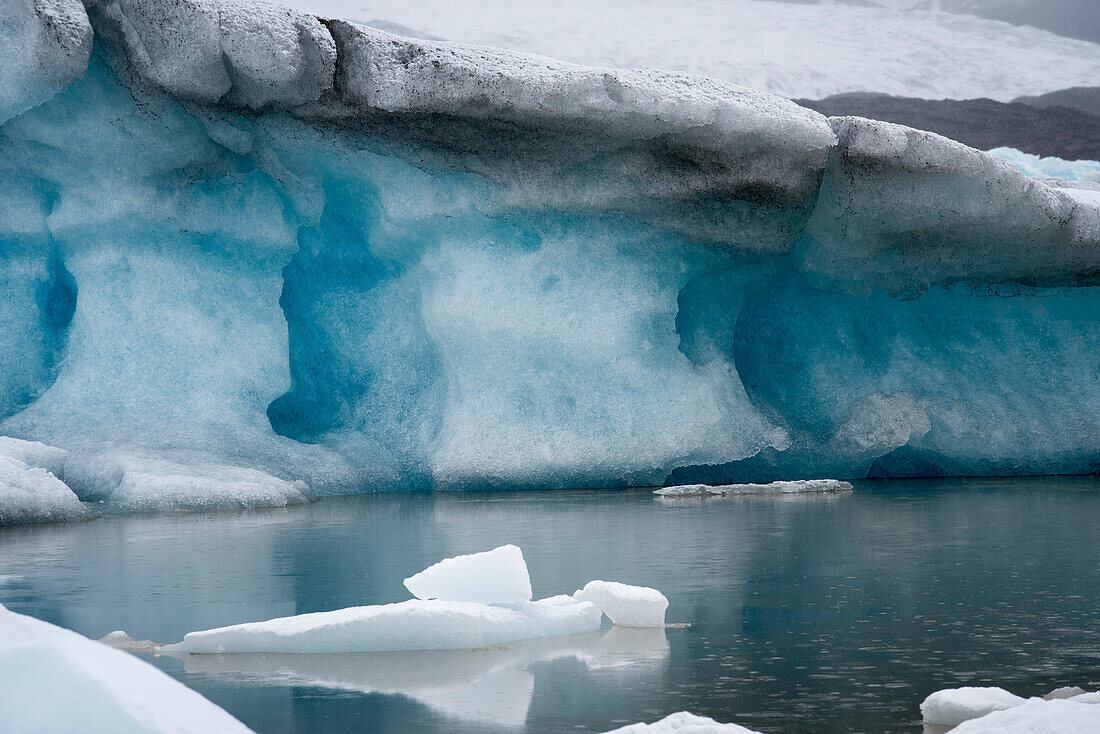 Nahaufnahme von Schneefall über Eisbergen entlang der Küste der Jokulsarlon Gletscherlagune; Vatnajokull National Park, Island