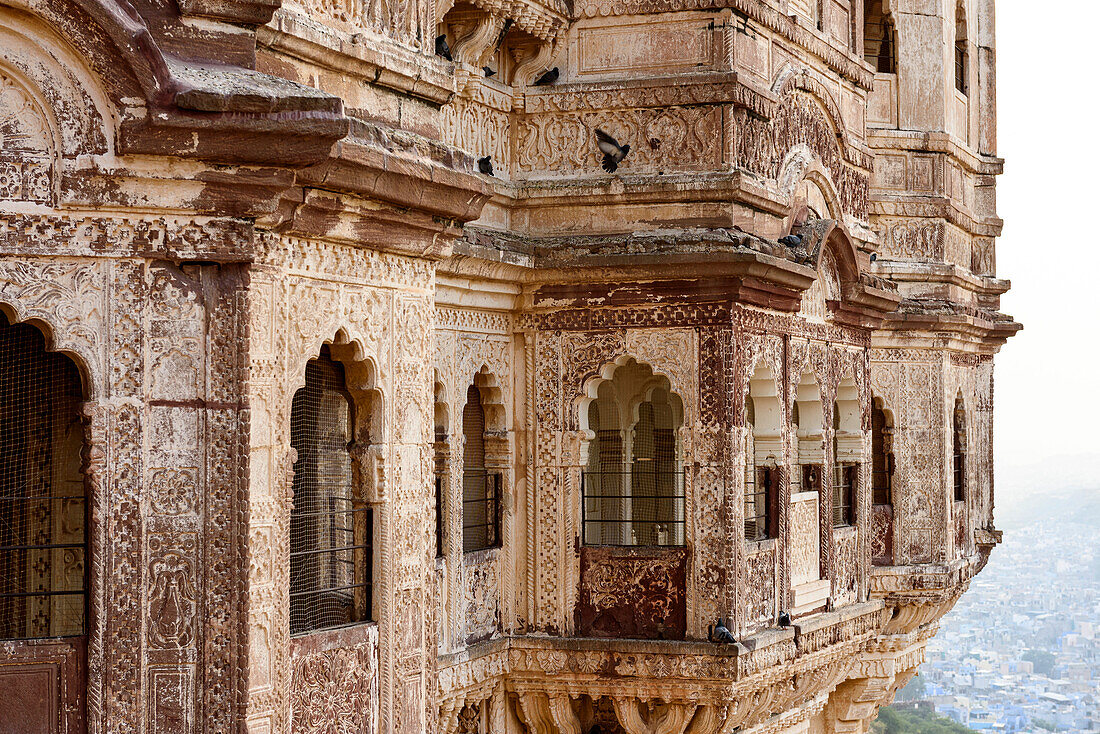 Nahaufnahme des detaillierten Mauerwerks des Mehrangarh Forts mit Blick auf die darunter liegende Stadt Jodhphur; Jodhpur, Rajasthan, Indien