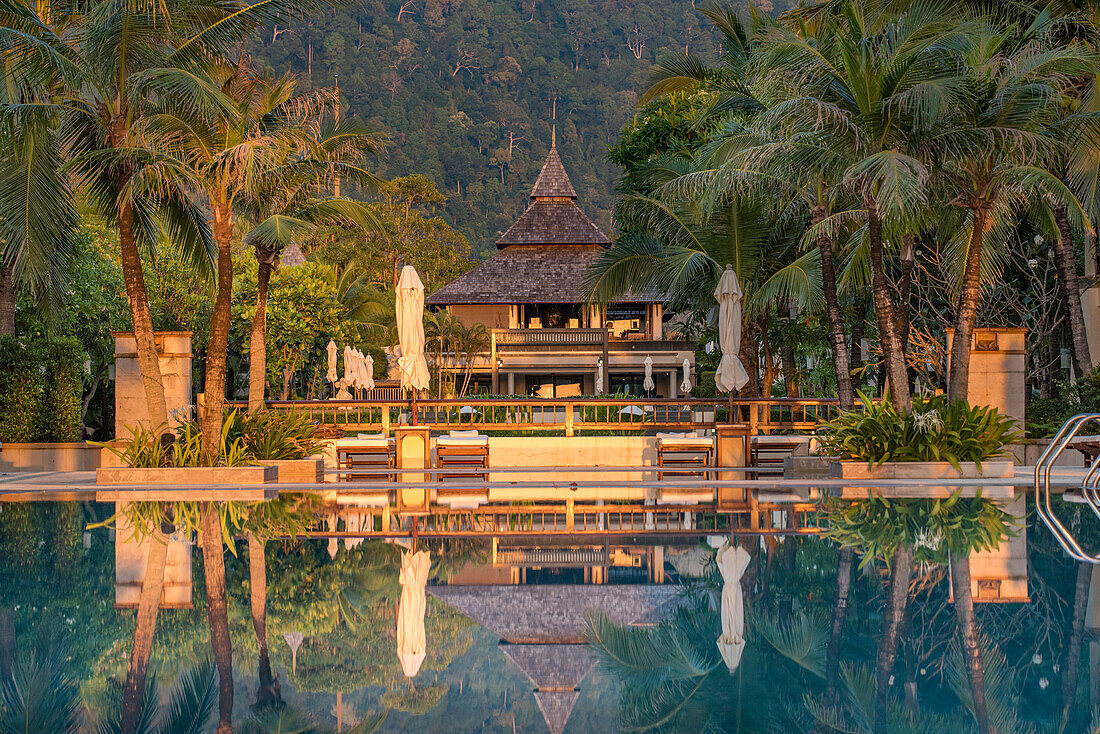 View of the reflection of a luxury hotel in swimming pool at sunset; Koh Lanta, Krabi Province, Thailand