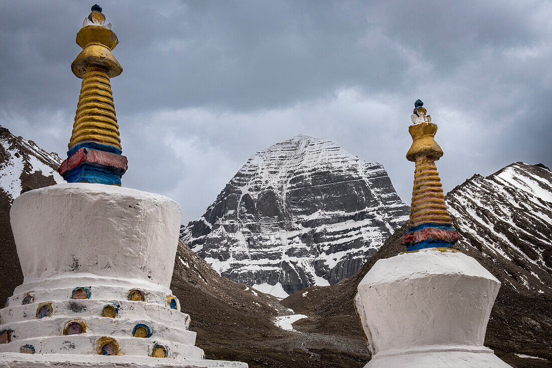 View of the snow-capped Mount Kailash, the Axis Mundi, Center of the World, with stupa pinnacles in the foreground; Burang County, Ngari Prefecture, Tibet Autonomous Region, Tibet