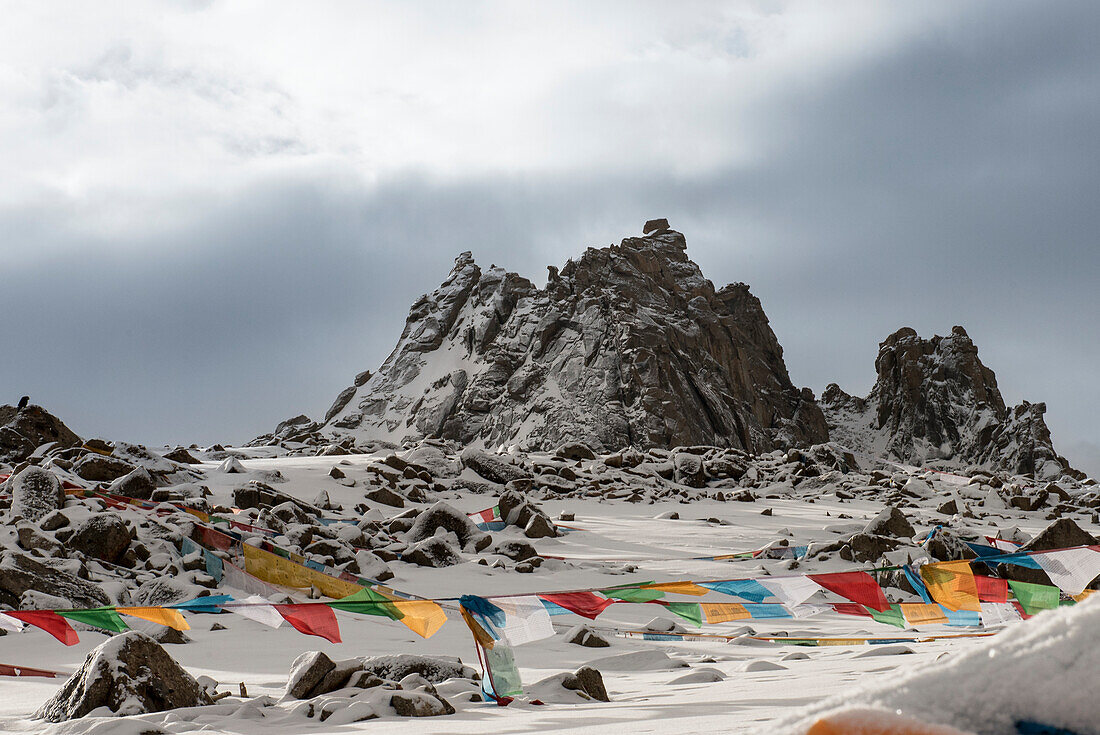 Drolma-La Pass und die schneebedeckte Landschaft am Mount Kailash mit Gebetsfahnen auf dem Gipfel; Burang County, Ngari Präfektur, Autonome Region Tibet, Tibet