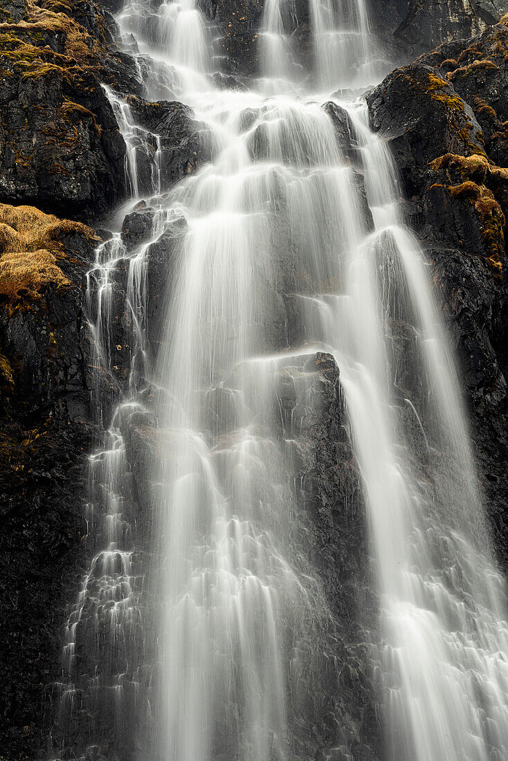 Nahaufnahme eines Wasserfalls in Island mit Wasserspritzern, die über eine schroffe Klippe fallen; Westfjorde, Island