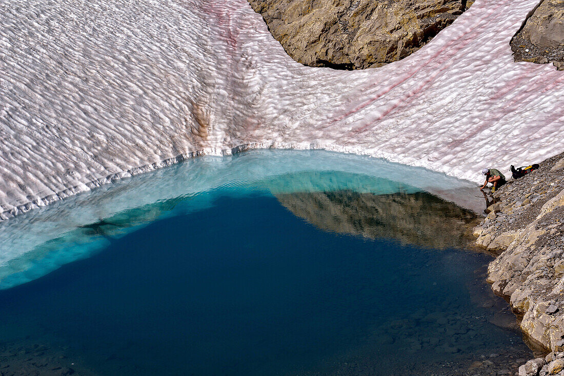 Ein Wissenschaftler sammelt eine Wasserprobe aus einem Oberflächenteich, der im Kalksteinkarst des Tsanfleuron-Gletschers im Sanetsch-Gebiet in der Schweiz versinkt