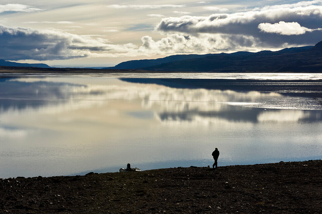 Expedition team member leaves his trusty boat behind him and the expanse of lake Centrum to take  a walk up to the limestone cliffs after another team member who had spotted a cave.