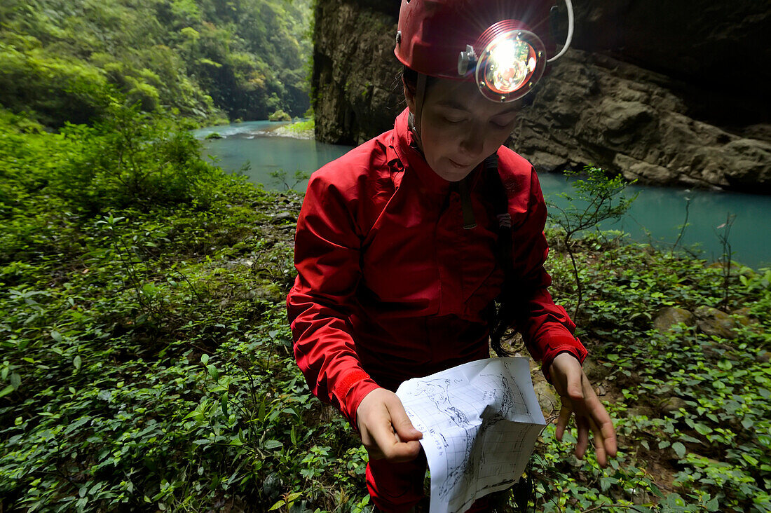 Ein Höhlenforscher studiert eine Papieraufnahme von Quankou Dong.