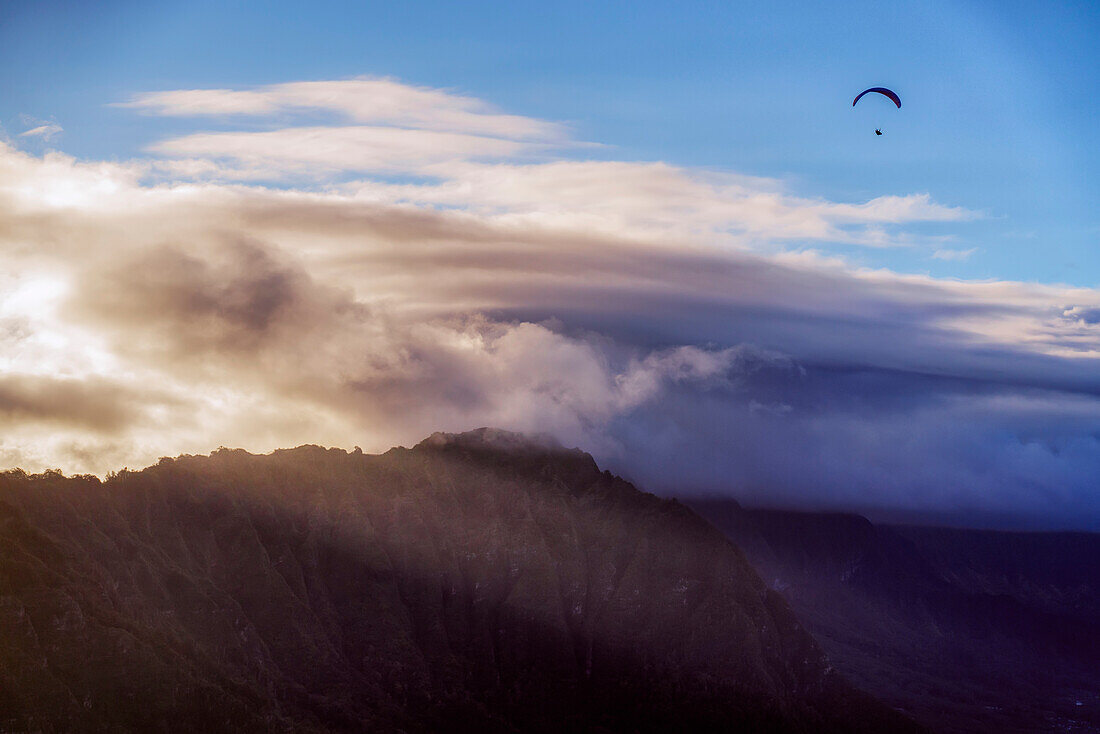 Gleitschirmfliegen über Berggipfel in der Dämmerung bei Honolulu; Oahu, Hawaii, Vereinigte Staaten von Amerika