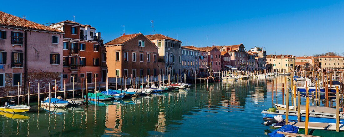 Bunte Gebäude und angedockte Boote am Ufer des Canale de San Pietro im Castello-Viertel von Venedig; Venetien, Venedig, Italien