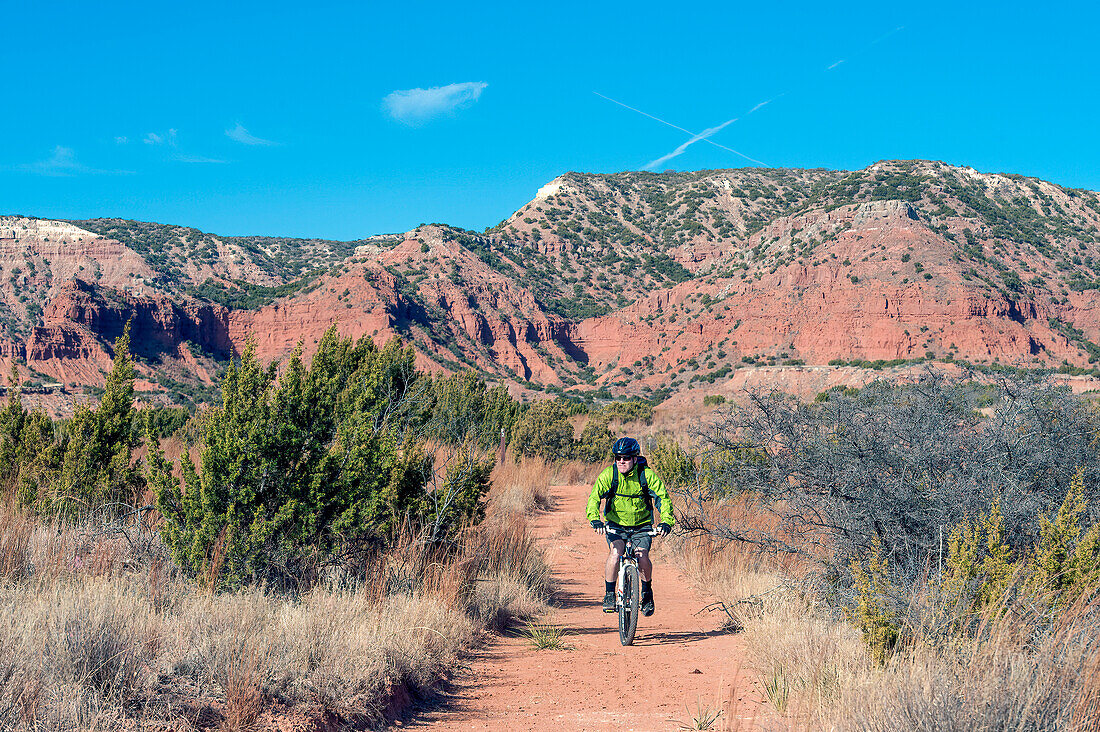 Man cycling through Caprock Canyons State Park and Trailway in Texas, USA; Quitaque, Texas, United States of America