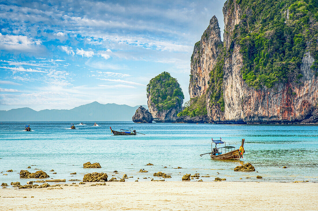 Longtail-Boote und eine Strandszene auf Koh Phi Phi, Thailand; Koh Phi Phi, Thailand