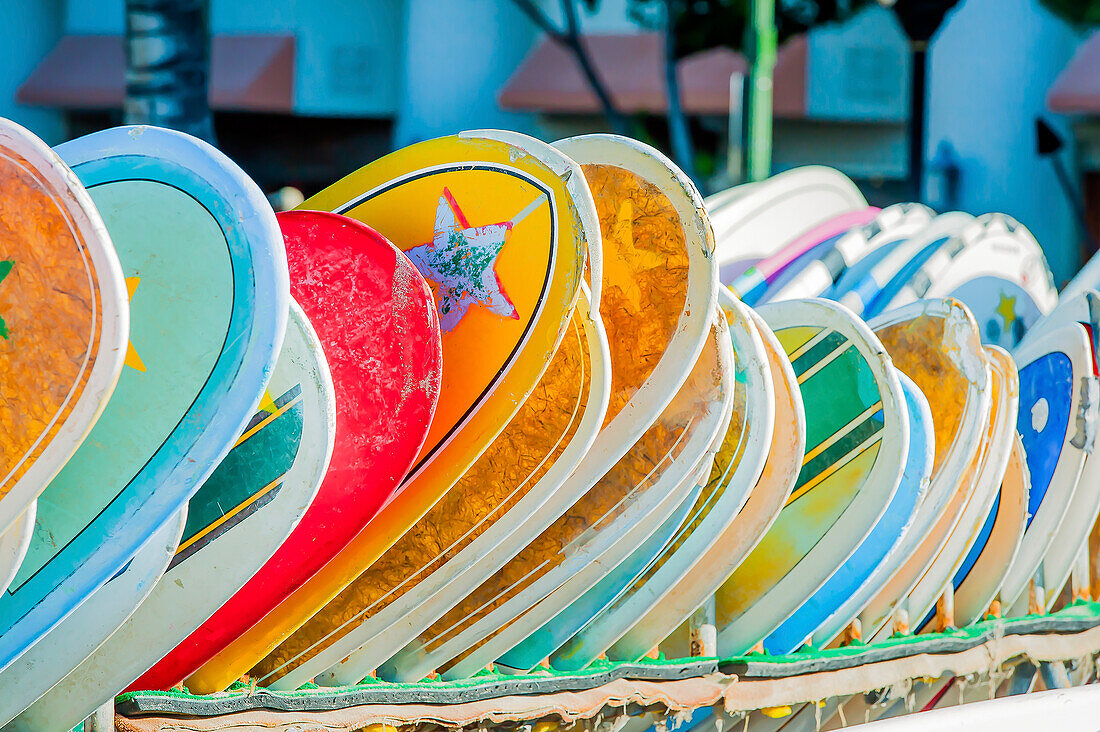 Colourful surfboards displayed in a row on Waikiki, Oahu, Hawaii, USA; Honolulu, Oahu, Hawaii, United States of America