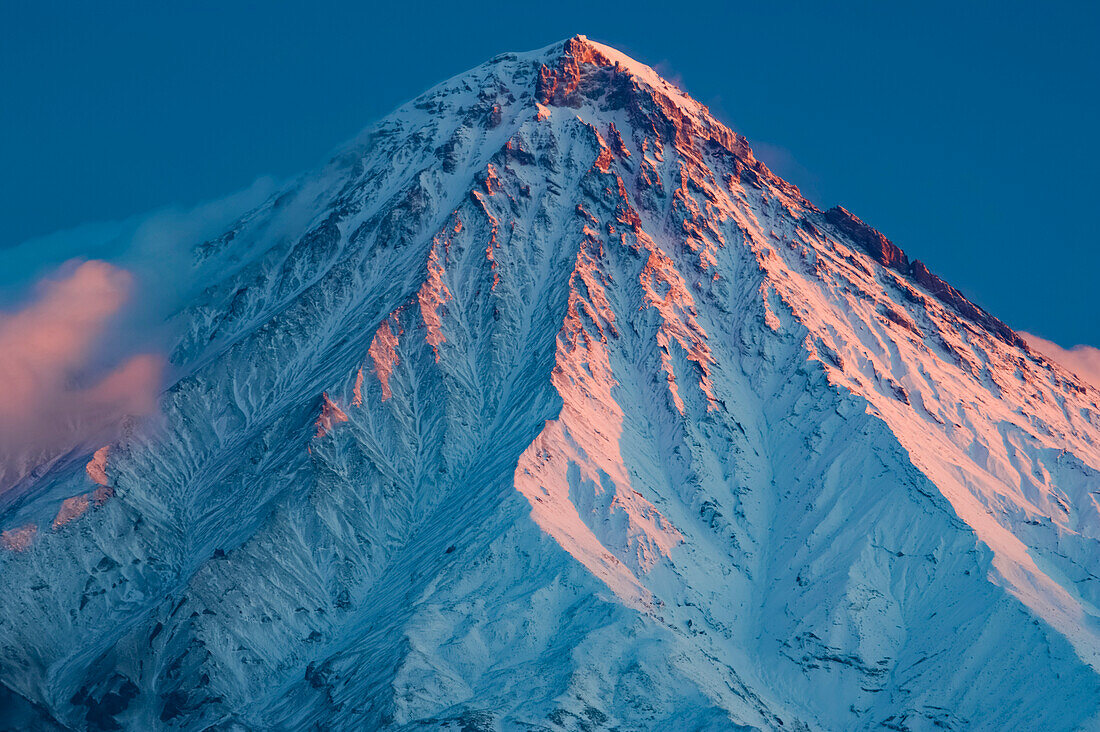 Sonnenuntergangslicht trifft auf den schneebedeckten Kronotsky-Vulkan, Russland; Kronotsky Zapovednik, Kamtschatka, Russland