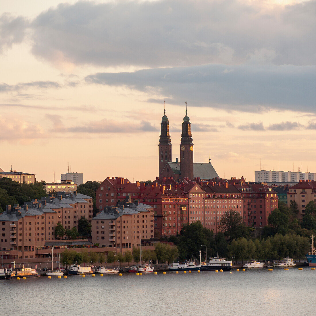 Boats Moored Along The Water's Edge At Sunset; Stockholm Sweden