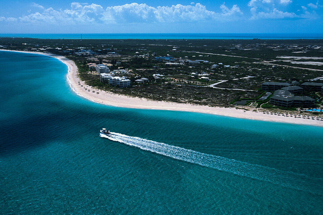 Aerial view of a boat sailing past an island; Turks and Caicos Islands, West Indies