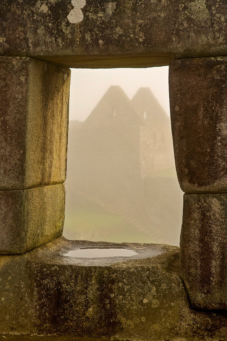 Wolkenumhüllte Gebäude auf Machu Picchu; Machu Picchu, Peru