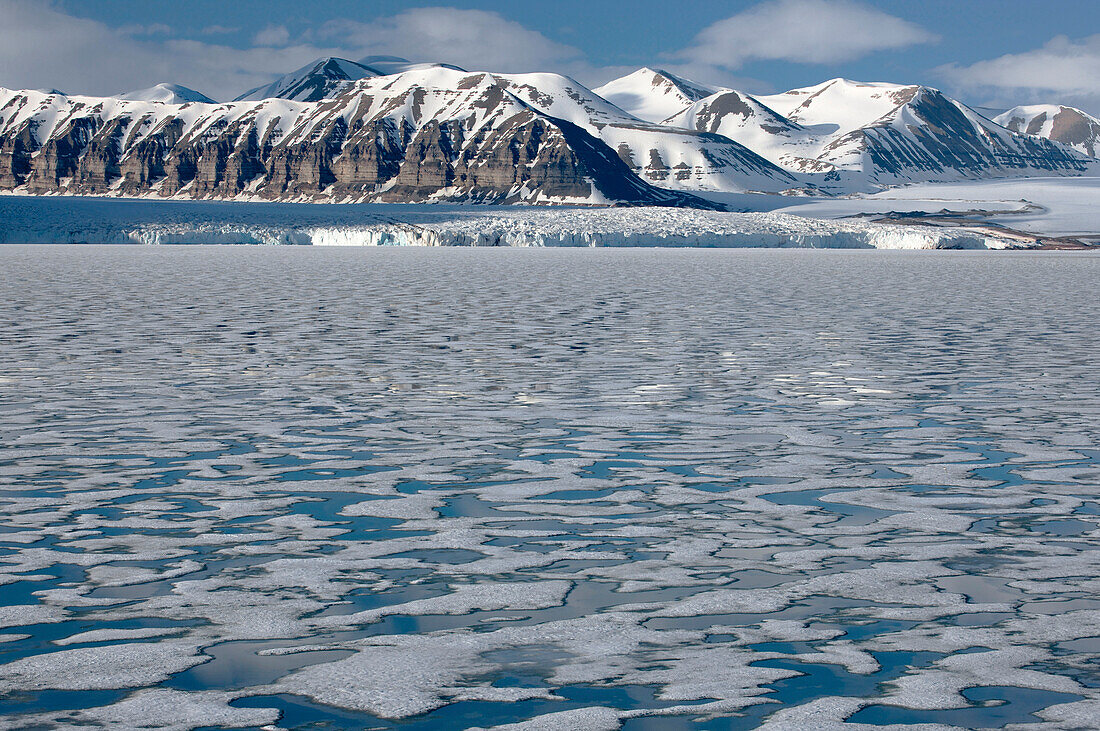 Ice in Tempelfjorden and a backdrop of mountains; Svalbard Archipelago, Norway