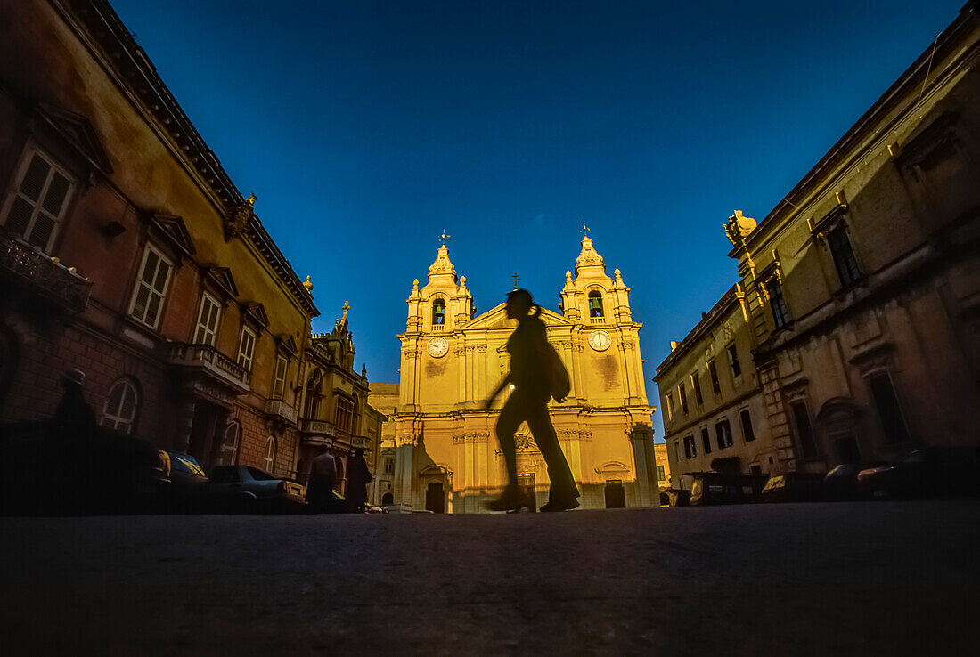 Silhouette of a woman walking past Saint Paul's Cathedral; Mdina, Malta Island, Malta