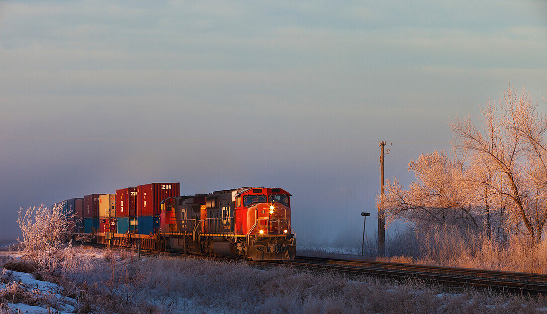Ein Zug fährt auf den Gleisen neben dem gefrorenen Boden; Parkland County Alberta Kanada