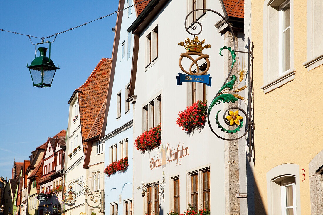 Hanging Sign And Lantern With Blossoming Flowers In Window Planter Boxes; Rothenburg Ob Der Tauber Bavaria Germany