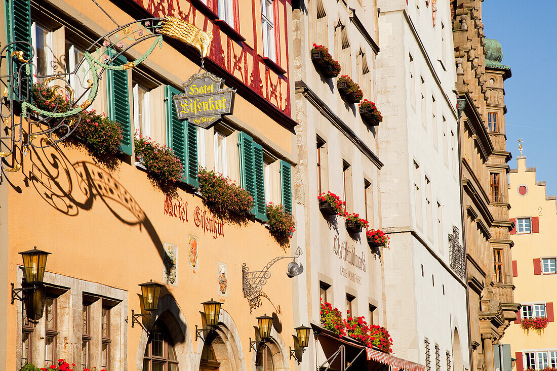 Bunte Gebäude in einer Reihe mit einem Hängeschild und Blumenkästen an den Fenstern; Rothenburg Ob Der Tauber Bayern Deutschland