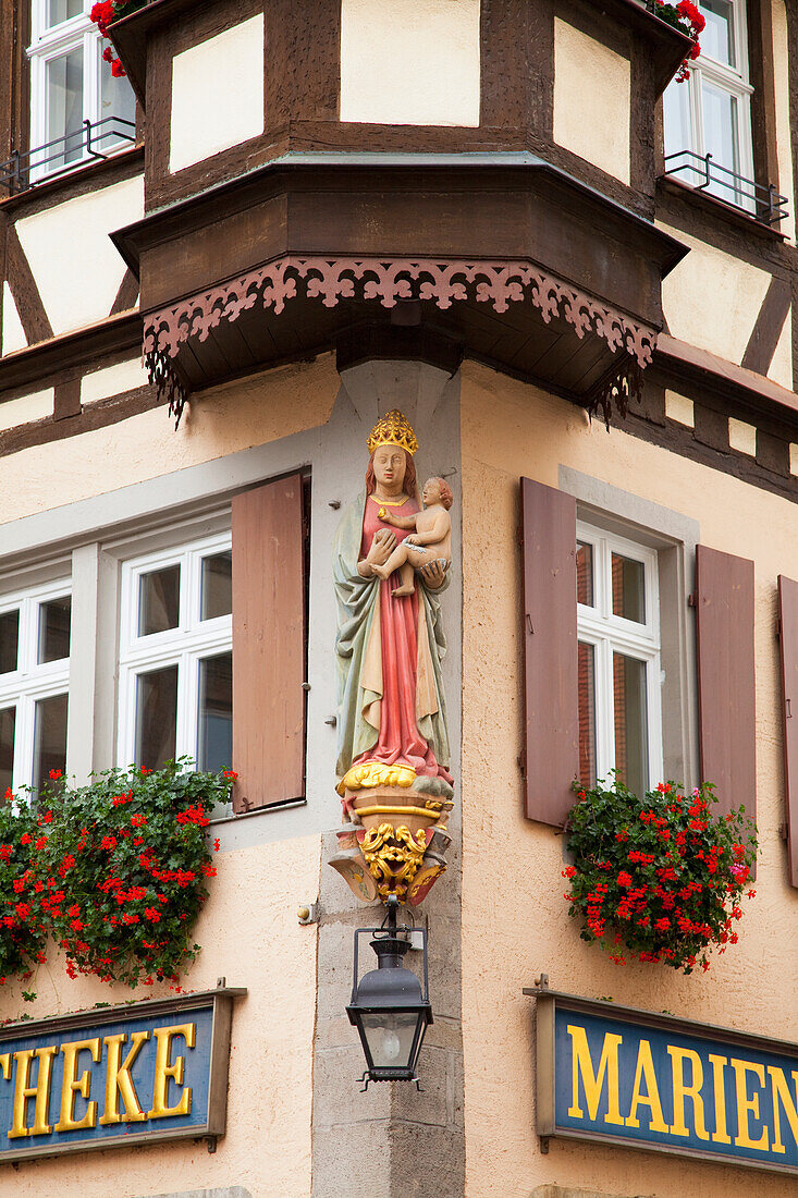Skulptur einer weiblichen Figur, die ein Baby hält, an der Ecke eines Gebäudes; Rothenburg Ob Der Tauber Bayern Deutschland