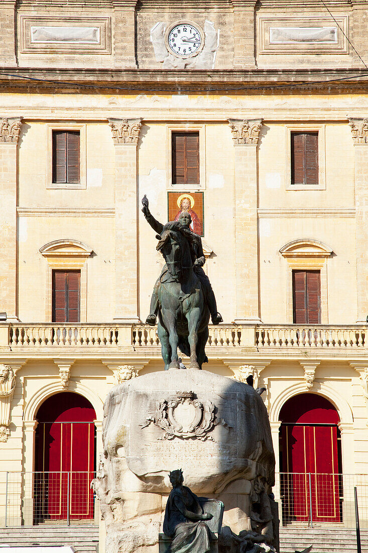 An Equestrian Statue With A Clock On A Building In The Background; San Fernando Andalusia Spain