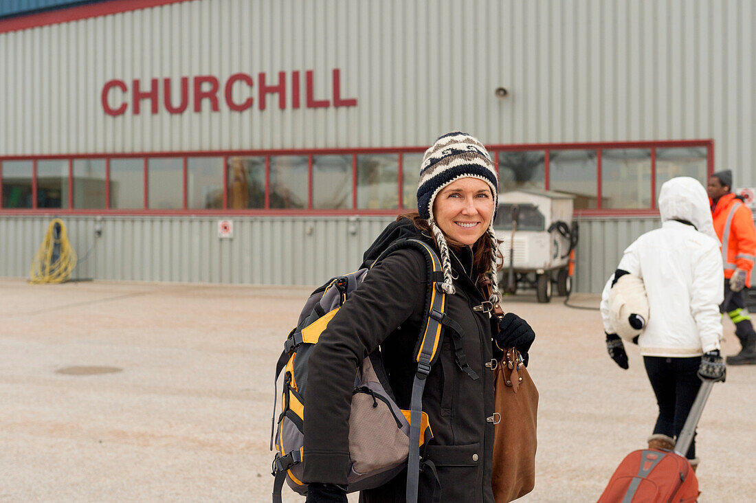 Eine Frau mit ihrem Gepäck auf der Rollbahn am Flughafen; Churchill Manitoba Kanada